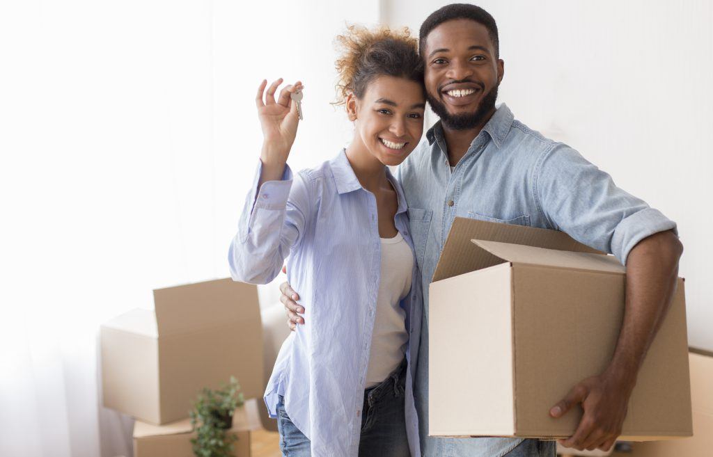Couple with a key and a moving box after Buying a House in Peterborough